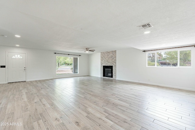 3743 E Coronado Rd, Phoenix, AZ 85008 - unfurnished living room featuring ceiling fan, light wood-style flooring, a large fireplace, visible vents, and baseboards