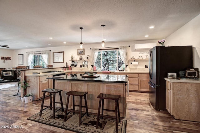 8894 W Lufkin Dr, Pine, AZ 85544 - kitchen featuring light brown cabinets, wood finished floors, freestanding refrigerator, a kitchen breakfast bar, and recessed lighting