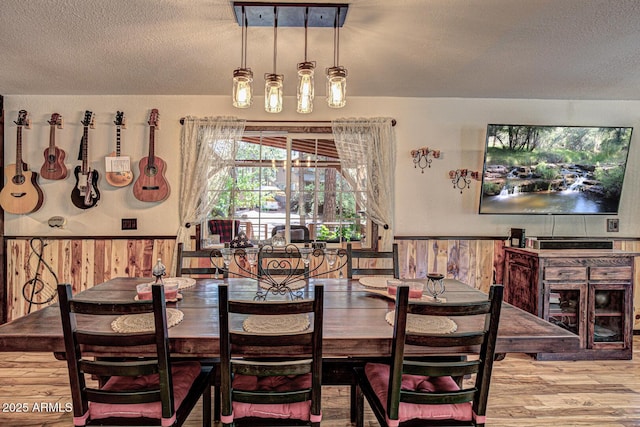8894 W Lufkin Dr, Pine, AZ 85544 - dining area with a textured ceiling, wainscoting, wood finished floors, and wooden walls