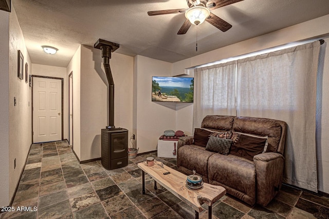 8894 W Lufkin Dr, Pine, AZ 85544 - living room featuring stone tile floors, a wood stove, and ceiling fan