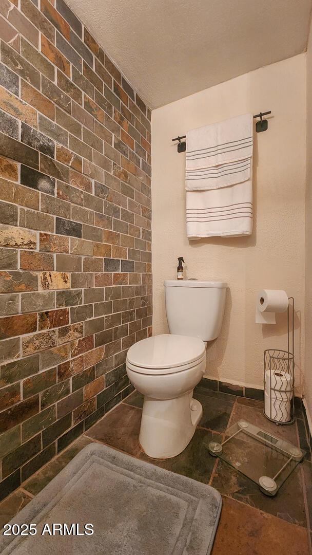 8894 W Lufkin Dr, Pine, AZ 85544 - bathroom with brick wall and tile patterned flooring