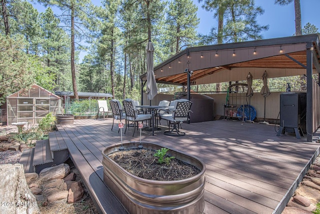 8894 W Lufkin Dr, Pine, AZ 85544 - wooden terrace with an exterior structure, a fenced backyard, an outbuilding, and outdoor dining space