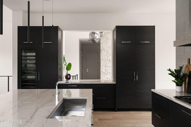 kitchen featuring pendant lighting, light hardwood / wood-style flooring, and sink