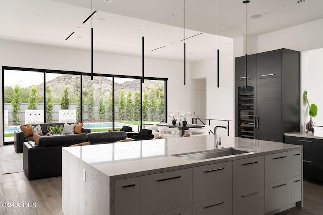 kitchen featuring a center island with sink, sink, a mountain view, and plenty of natural light