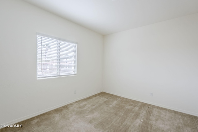 spare room with light carpet and baseboards