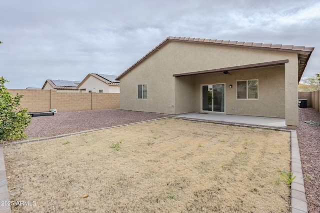 back of house with a ceiling fan, a patio area, a fenced backyard, and stucco siding