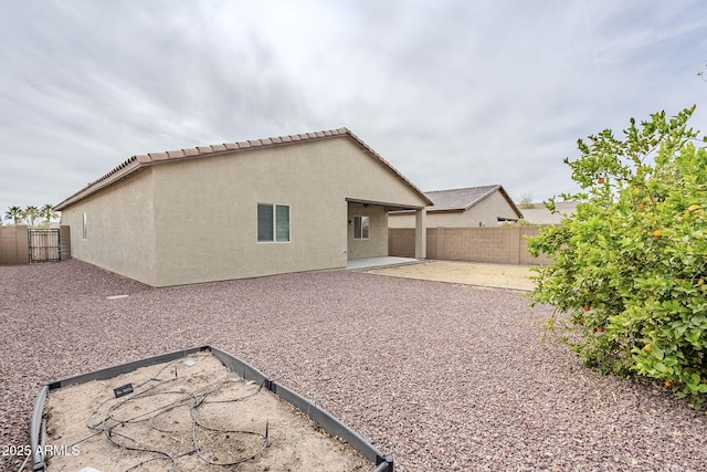 back of house featuring stucco siding, a fenced backyard, and a patio