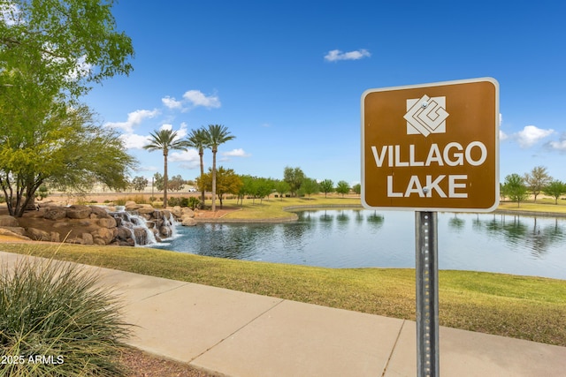 view of home's community with a lawn and a water view