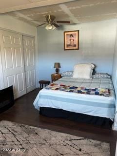 bedroom featuring ceiling fan, dark wood-type flooring, and a closet