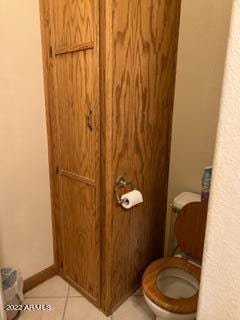 bathroom featuring tile flooring and toilet