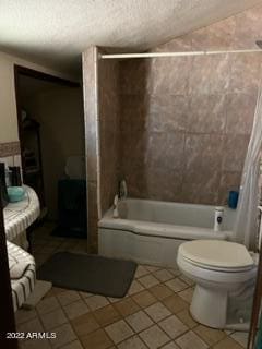 bathroom with tile flooring, toilet, and tiled shower / bath