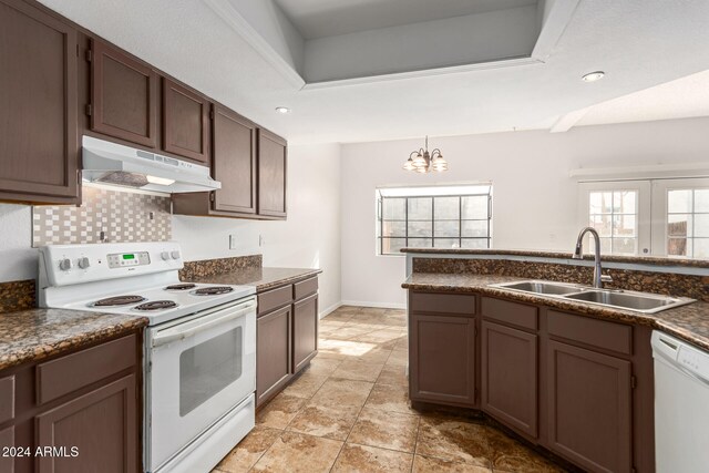 kitchen featuring backsplash, decorative light fixtures, white appliances, sink, and a chandelier