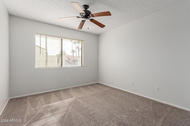 carpeted empty room featuring ceiling fan and a textured ceiling