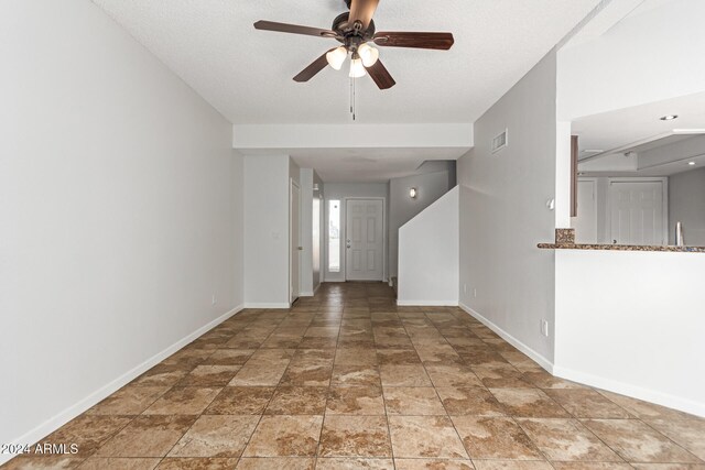 interior space featuring ceiling fan and a textured ceiling