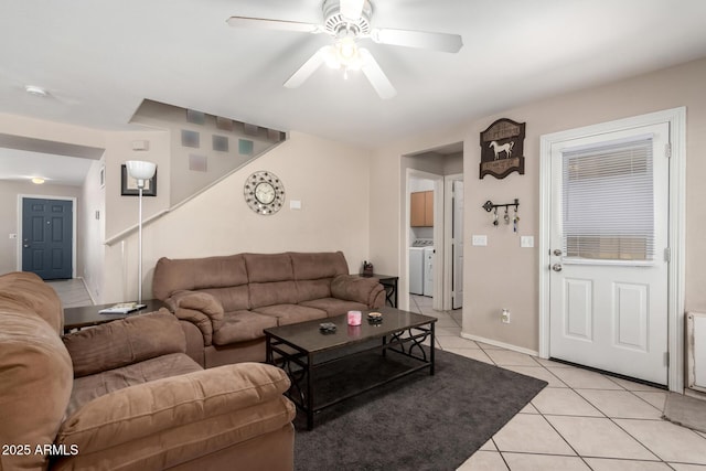 living room with a ceiling fan, light tile patterned floors, and washing machine and clothes dryer