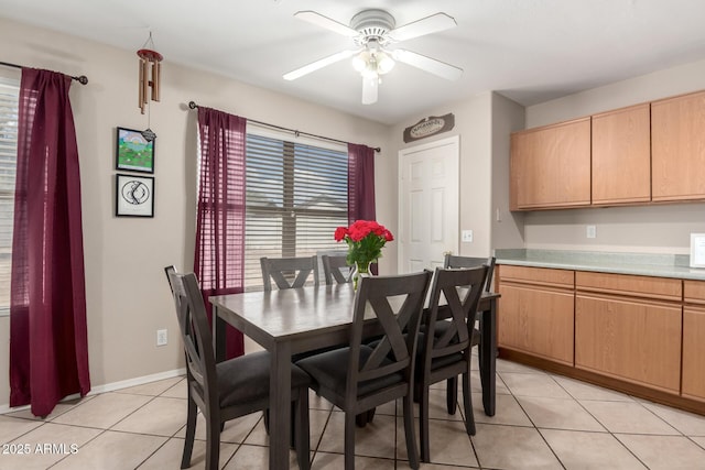 dining space with baseboards, a ceiling fan, and light tile patterned floors