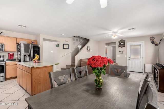 dining area with ceiling fan, visible vents, stairway, and light tile patterned floors