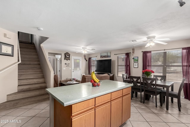 kitchen featuring light tile patterned floors, visible vents, a center island, and ceiling fan