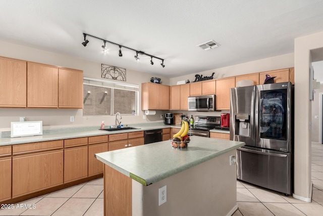 kitchen with a sink, light brown cabinetry, appliances with stainless steel finishes, light tile patterned floors, and visible vents