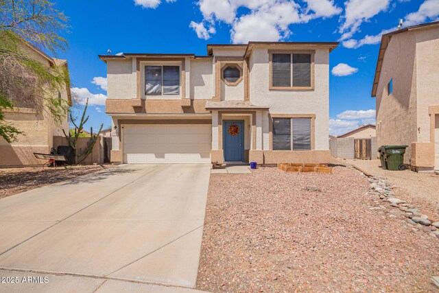 view of front of property with concrete driveway, stucco siding, fence, and an attached garage