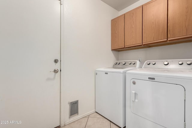 laundry area with light tile patterned flooring, washing machine and clothes dryer, and cabinet space