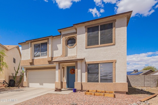 view of front of house featuring concrete driveway, stucco siding, fence, and an attached garage