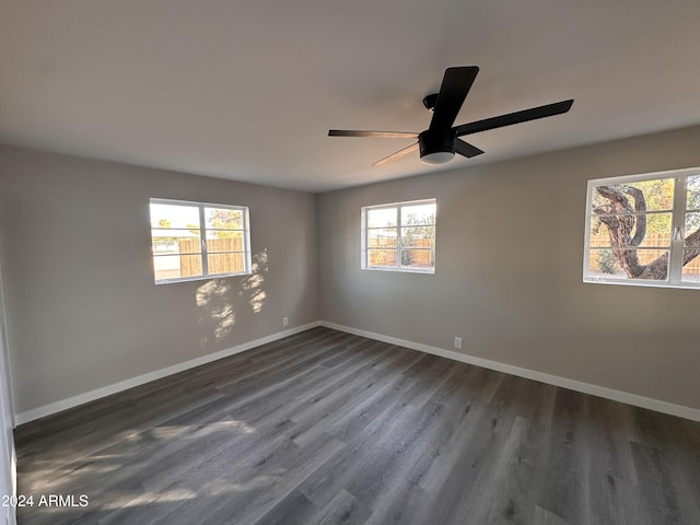 empty room with ceiling fan and dark wood-type flooring