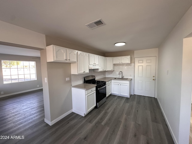 kitchen with backsplash, white cabinetry, stainless steel range with gas cooktop, and sink