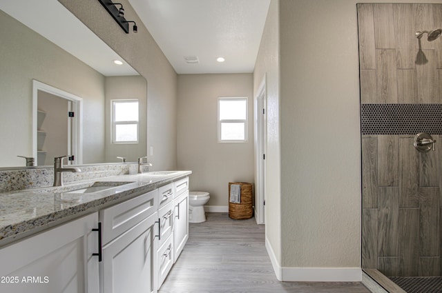 bathroom featuring a tile shower, a wealth of natural light, and toilet