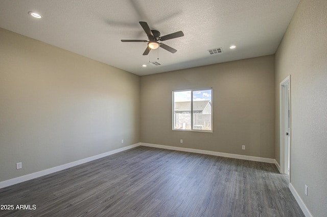 spare room with dark hardwood / wood-style floors, a textured ceiling, and ceiling fan