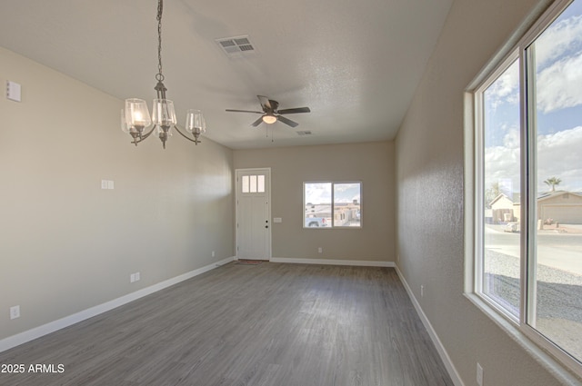 spare room with dark hardwood / wood-style flooring, ceiling fan with notable chandelier, and a textured ceiling