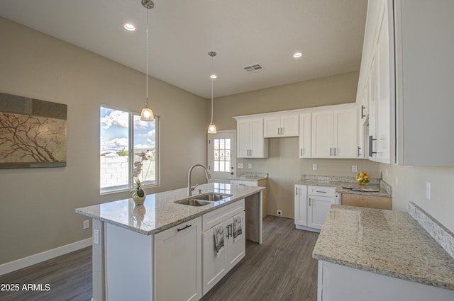 kitchen featuring white cabinetry, sink, dark hardwood / wood-style floors, and a center island with sink