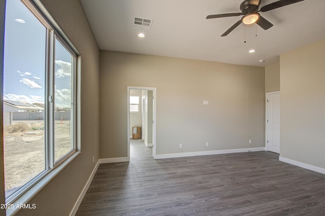 unfurnished room featuring plenty of natural light, dark hardwood / wood-style floors, and ceiling fan