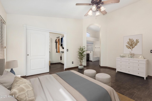6502 W Wahalla Ln, Glendale, AZ 85308 - bedroom featuring arched walkways, dark wood-type flooring, connected bathroom, a closet, and a walk in closet