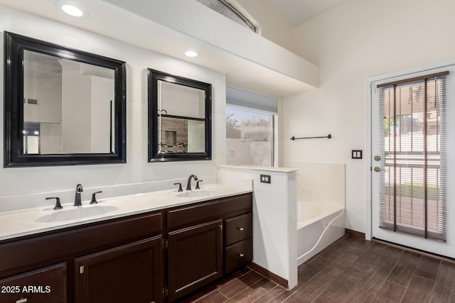 6502 W Wahalla Ln, Glendale, AZ 85308 - bathroom with a garden tub, double vanity, wood finished floors, and recessed lighting