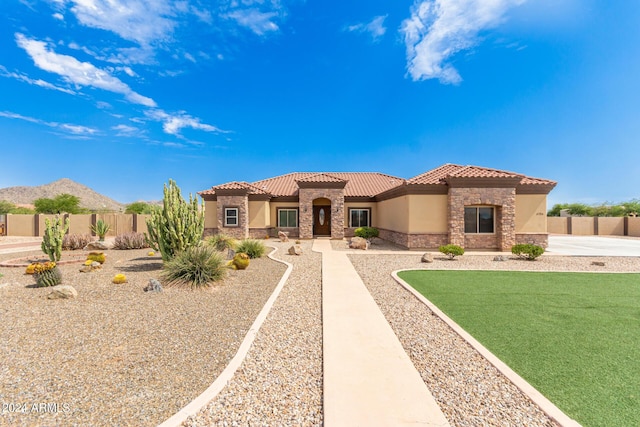 mediterranean / spanish-style house with a mountain view and a front yard