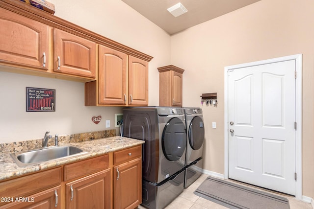 laundry area featuring light tile patterned flooring, cabinets, sink, and washer and dryer