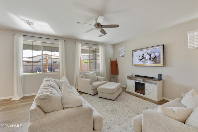 living room with light hardwood / wood-style flooring and ceiling fan