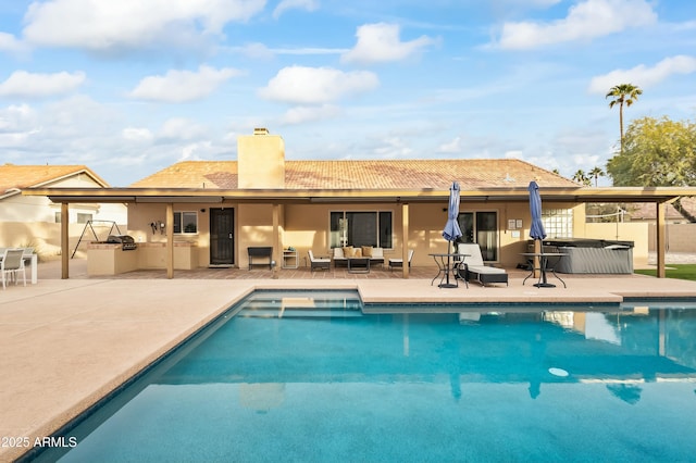 view of swimming pool with an outdoor living space, a hot tub, an outdoor kitchen, and a patio