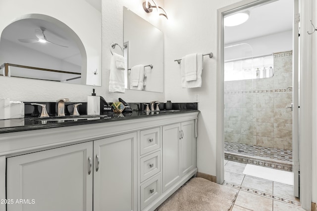 bathroom featuring tiled shower, vanity, ceiling fan, and tile patterned flooring