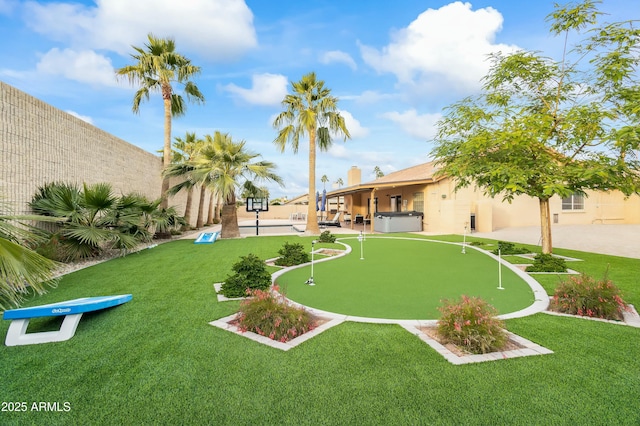 view of community featuring a yard and a hot tub