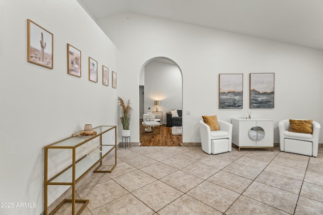 living area featuring light tile patterned floors and vaulted ceiling