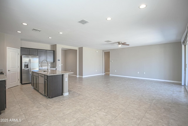 kitchen with a kitchen island with sink, a sink, visible vents, open floor plan, and appliances with stainless steel finishes