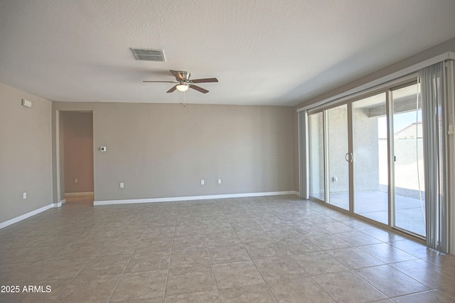 empty room featuring ceiling fan, a textured ceiling, visible vents, and baseboards