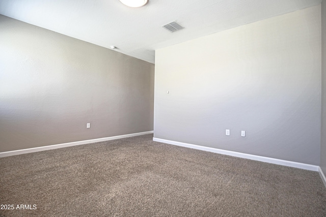 carpeted spare room with visible vents and baseboards