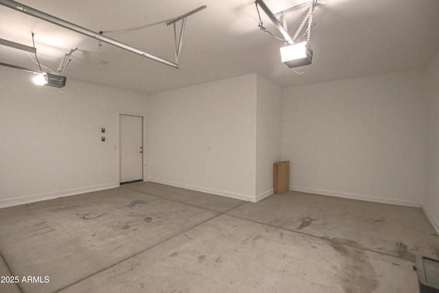 garage featuring a garage door opener and baseboards