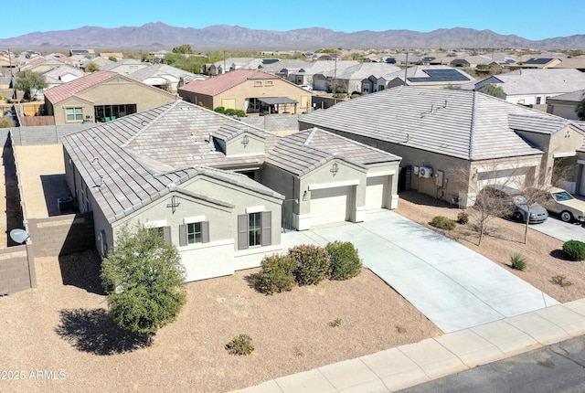 view of front of property with an attached garage, a residential view, and a mountain view