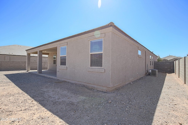 rear view of house featuring central AC, a patio area, a fenced backyard, and stucco siding