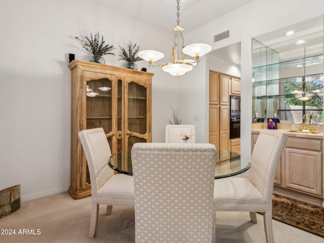 carpeted dining room with sink and an inviting chandelier