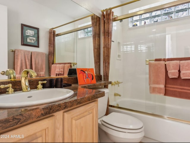 full bathroom featuring vanity, toilet, and enclosed tub / shower combo